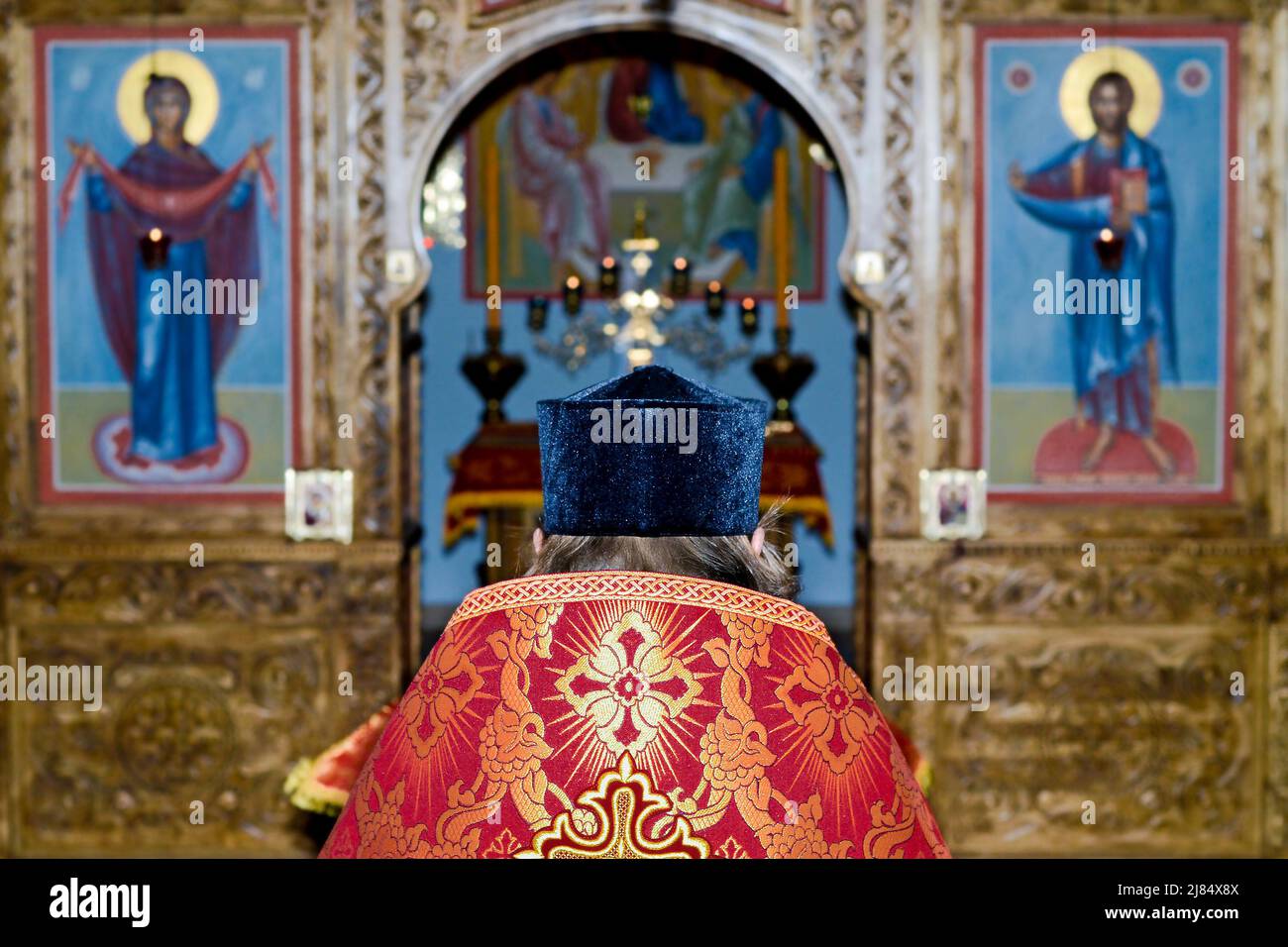 Der orthodoxe Priester betet am Altar in der russischen Kirche Stockfoto