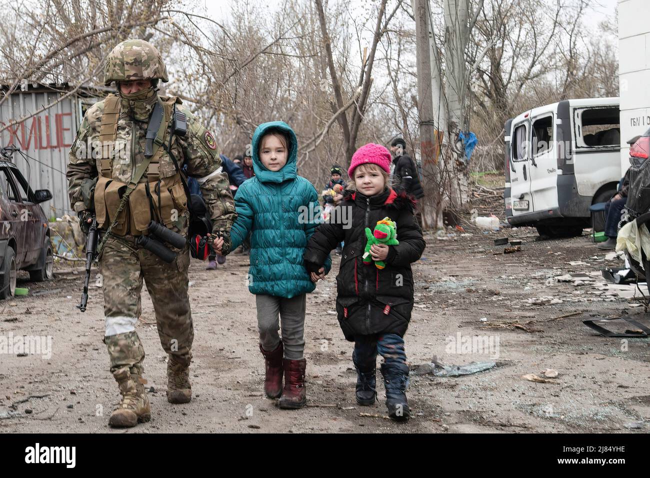 Mariupol, Ukraine. 14. April 2022. Ein russischer Soldat begleitet zwei kleine Kinder in das Bombenschutzhaus, das ihre Familie mehr als sechs Wochen lang in Mariupol untergebracht hatte. Der Kampf zwischen den russisch-prorussischen Streitkräften und den vom Asow-Bataillon angeführten trotzenden ukrainischen Streitkräften dauert in der Hafenstadt Mariupol an. (Foto: Maximilian Clarke/SOPA Images/Sipa USA) Quelle: SIPA USA/Alamy Live News Stockfoto