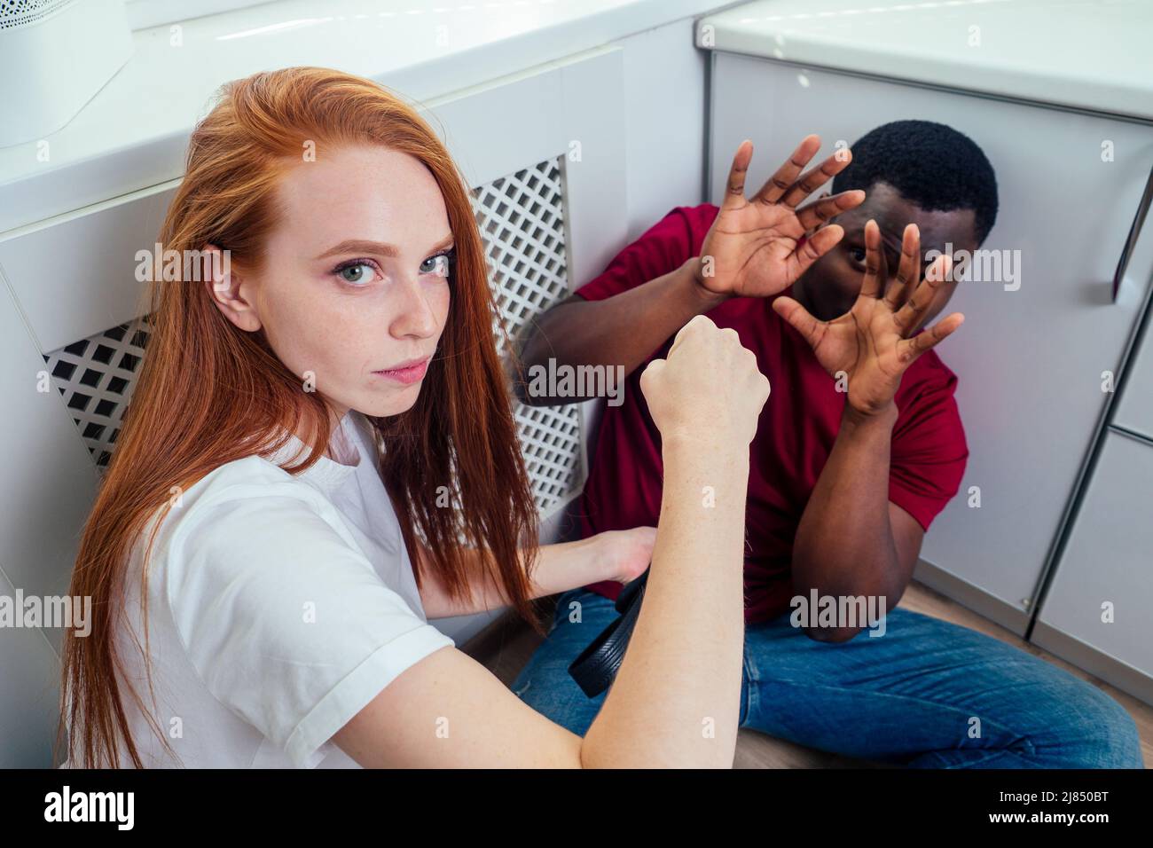 Häusliche Gewalt. Wütendes Mädchen trifft afroamerikanischen Mann in der Küche Stockfoto