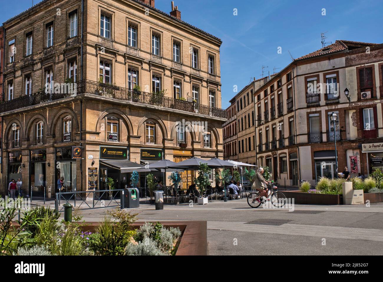 Toulouse, Place Belfort, Haute-Garonne Frankreich 05.10.2022 hübscher Platz im Stadtzentrum. Café und Teeladen. Gelbe Backsteinarchitektur. Bogenfenster Stockfoto