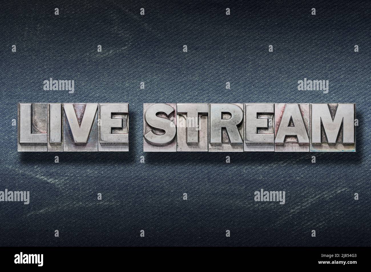 Live-Stream-Phrase aus Metallic-Buchdruck auf dunklem Jeans-Hintergrund Stockfoto