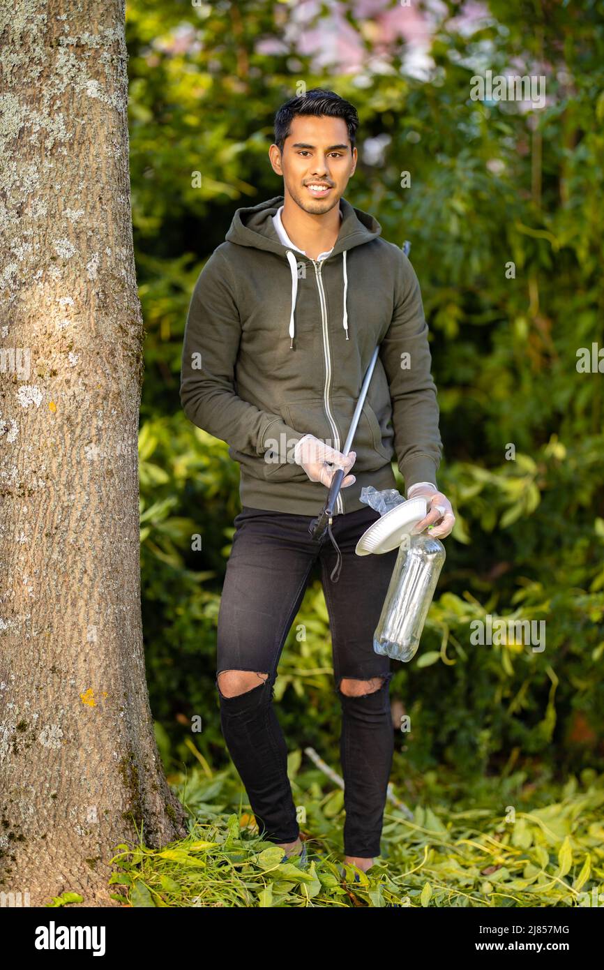 Umweltschutz Freiwilliger hält Plastikmüll und mechanischen Grabber Stockfoto