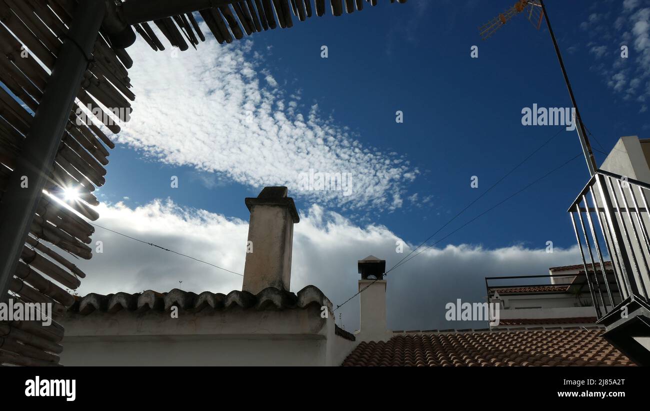 Kamine und graue und weiße Wolken von der Unterseite der Bambusdachverkleidung aus gesehen Stockfoto