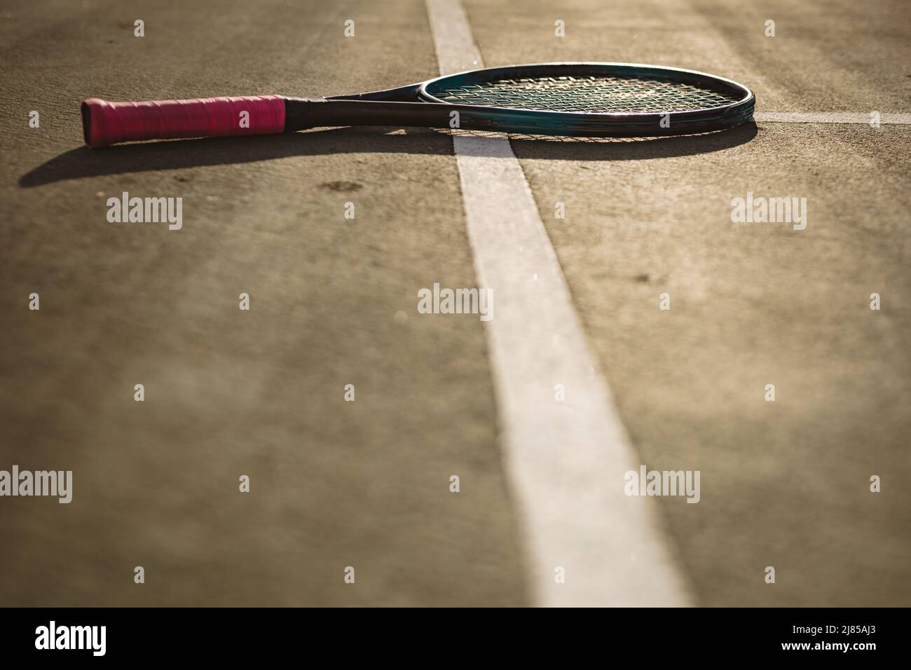 Oberfläche des Tennisschlägers auf weißen Linien auf dem Tennisplatz bei Sonnenuntergang, Platz zum Kopieren Stockfoto