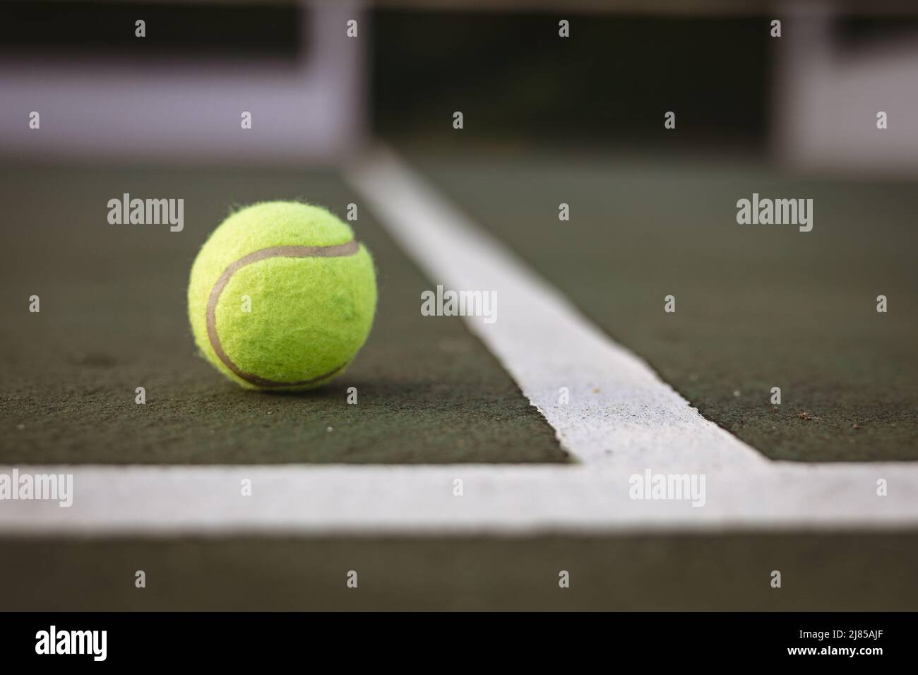 Nahaufnahme des gelben Tennisballs durch weiße Linien auf dem Tennisplatz, Kopierbereich Stockfoto