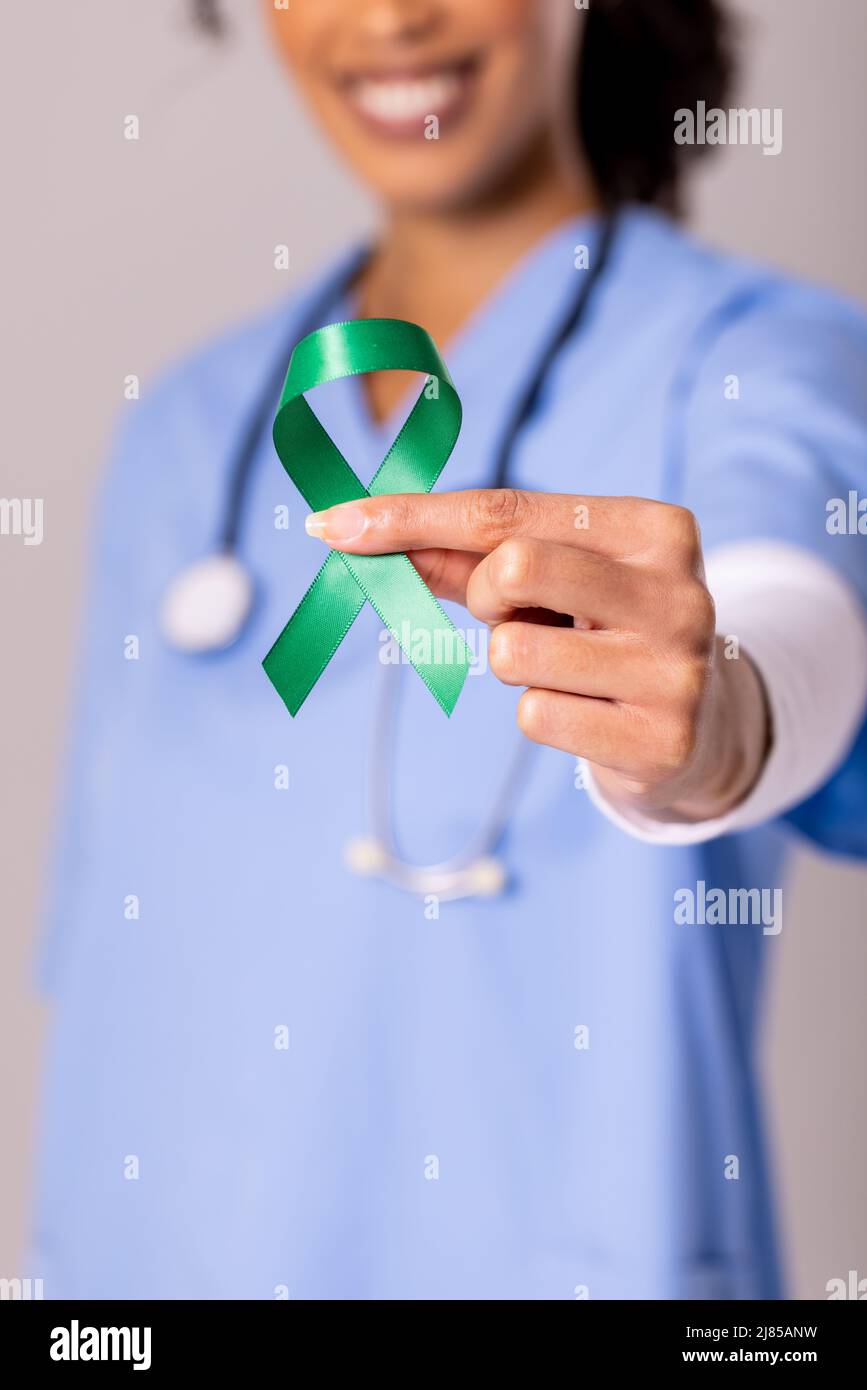 Mittelteil einer afroamerikanischen Ärztin mit mittlerem Erwachsenen und grünem Band zur Sensibilisierung für die psychische Gesundheit Stockfoto