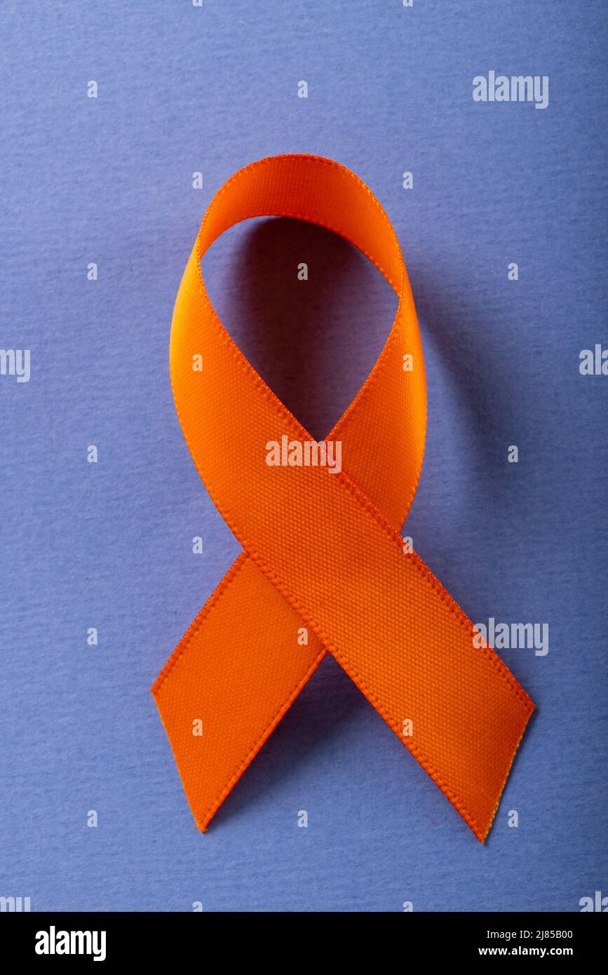 Nahaufnahme eines orangefarbenen Leukämie-Sensibilisierungsbandes, isoliert vor blauem Hintergrund, Kopierbereich Stockfoto