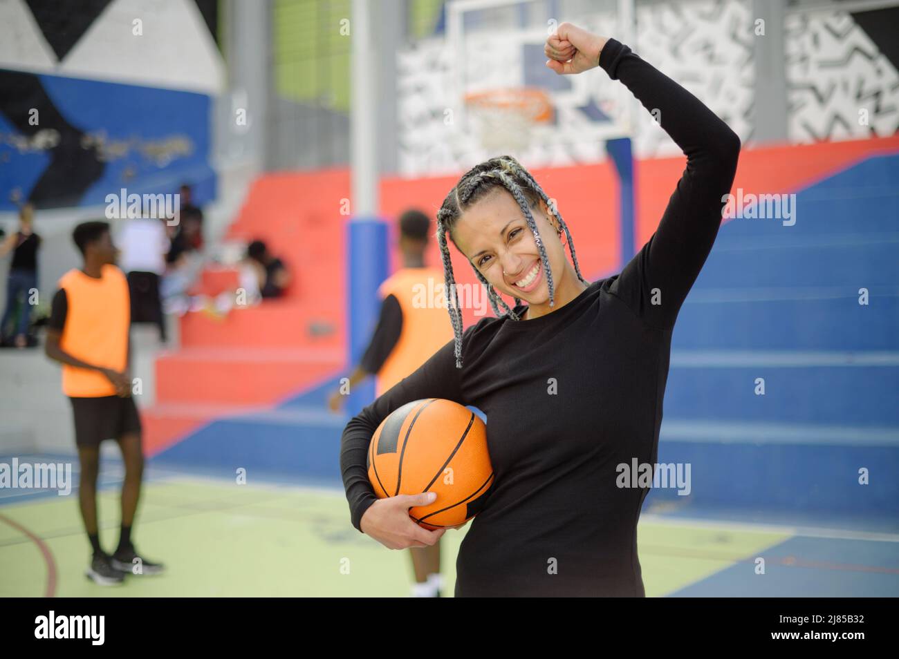 Positive schwarze Sportlerin feiert den Sieg auf dem Basketballplatz Stockfoto