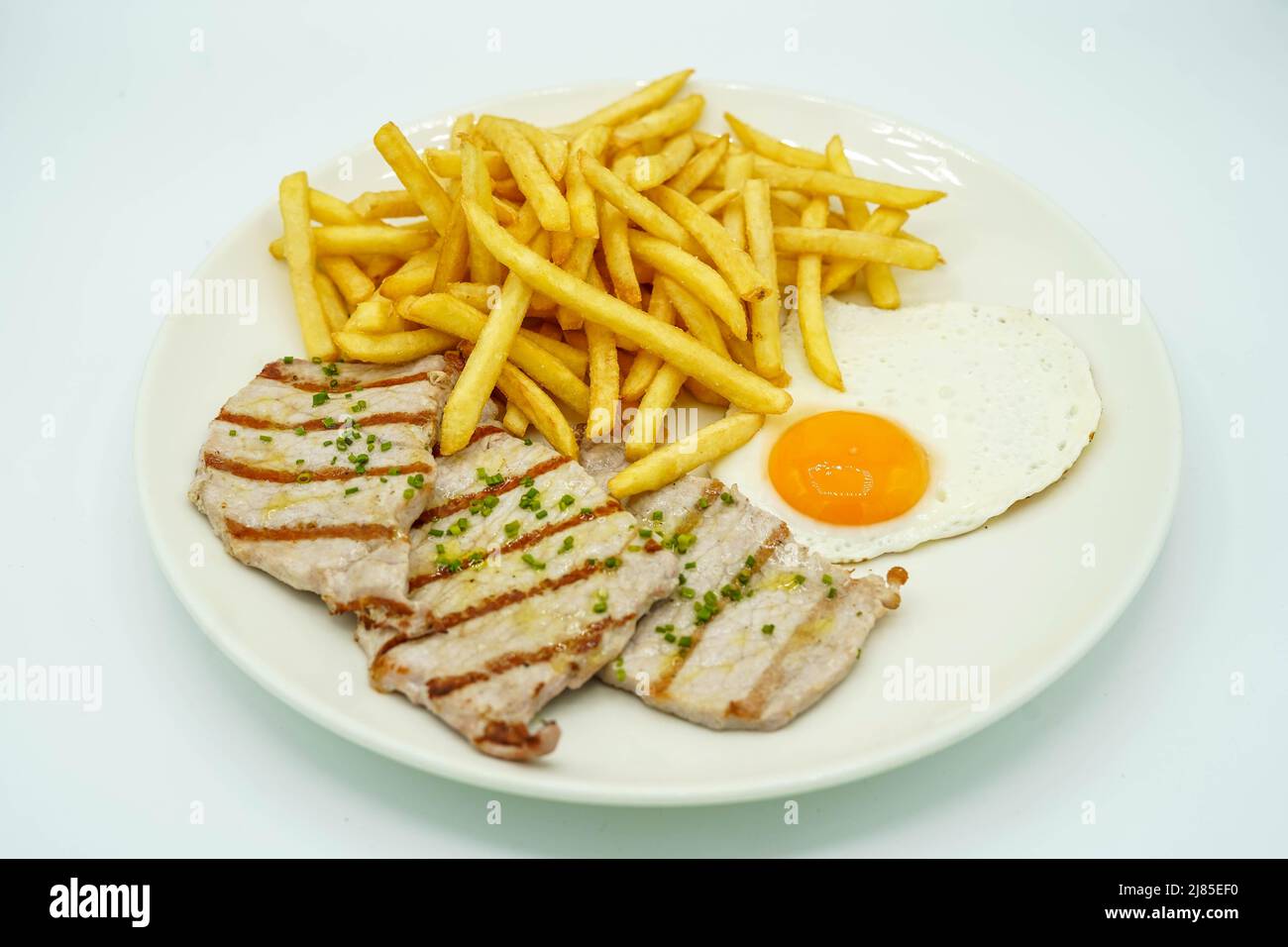 Kombinierter Teller mit Schweinelende mit Kartoffeln und Spiegelei Stockfoto