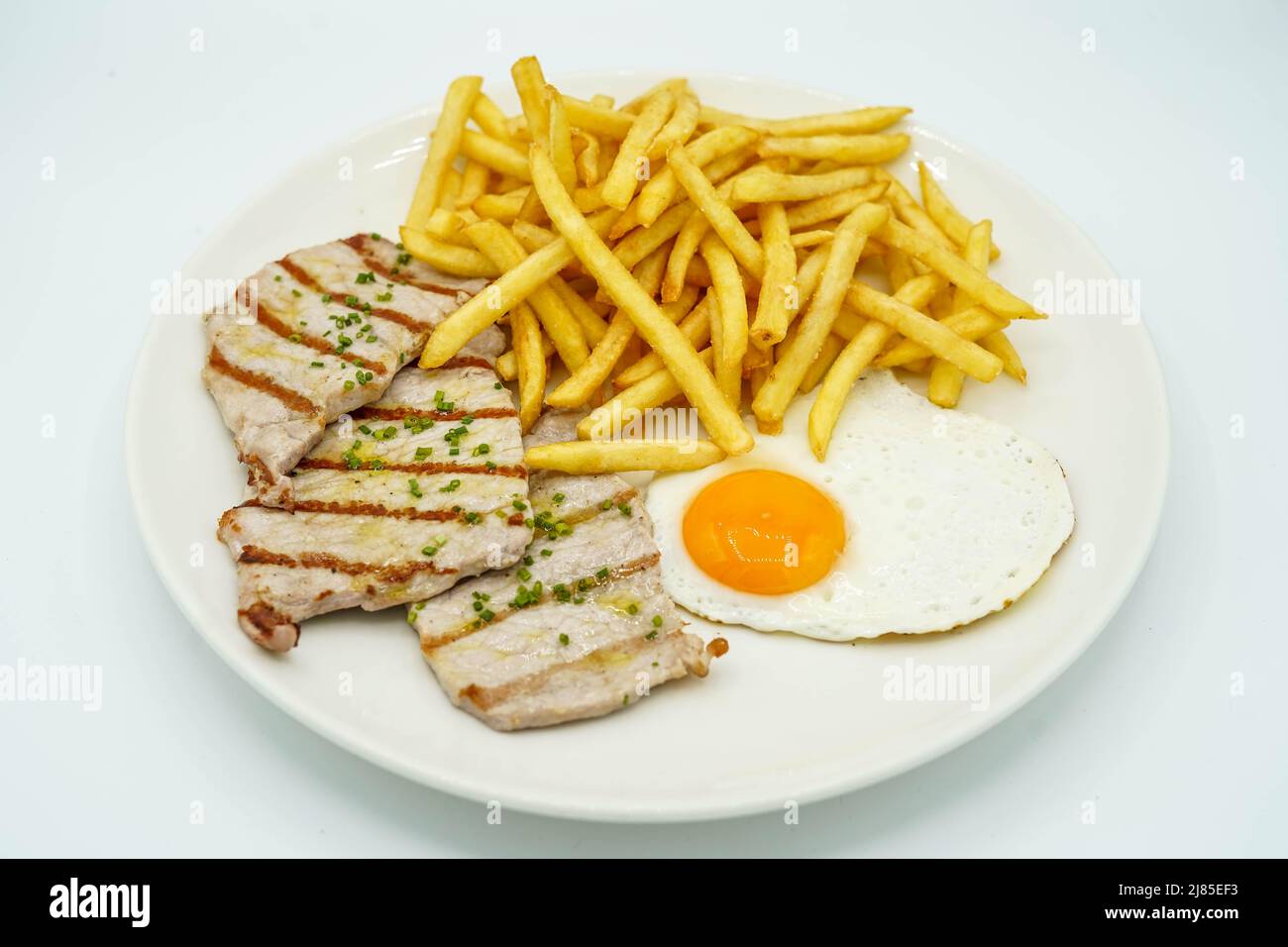 Kombinierter Teller mit Schweinelende mit Kartoffeln und Spiegelei Stockfoto