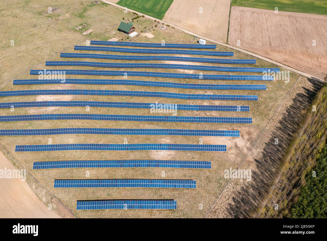 Solarfarm Luftaufnahme, Reihen von PV-Modulen bei einem kleinen Haus Stockfoto