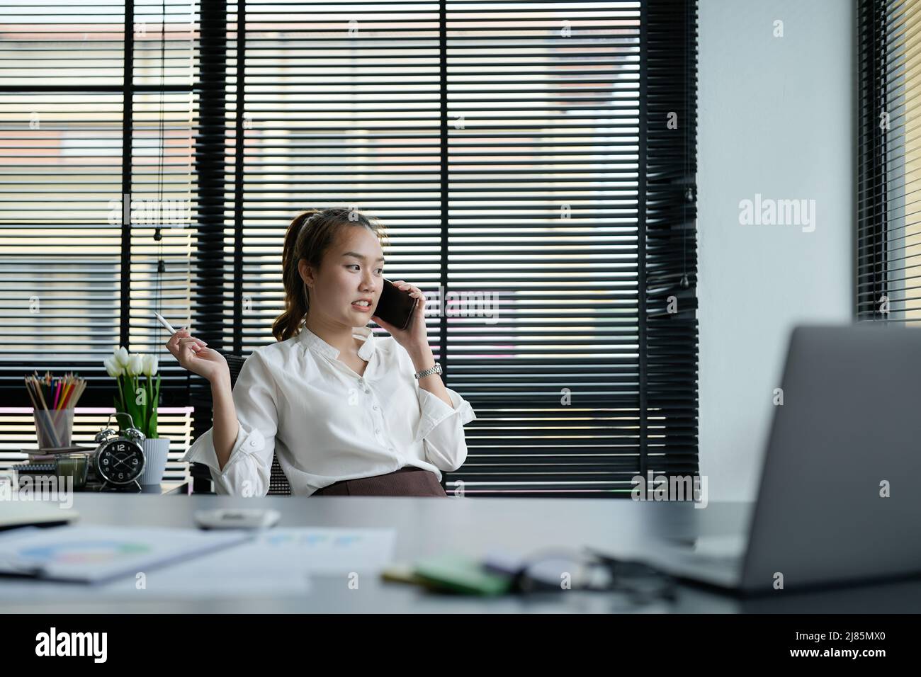Portrait asiatische Geschäftsfrau, die einen Anruf macht und lächelt, während sie im IT-Büro arbeitet Stockfoto
