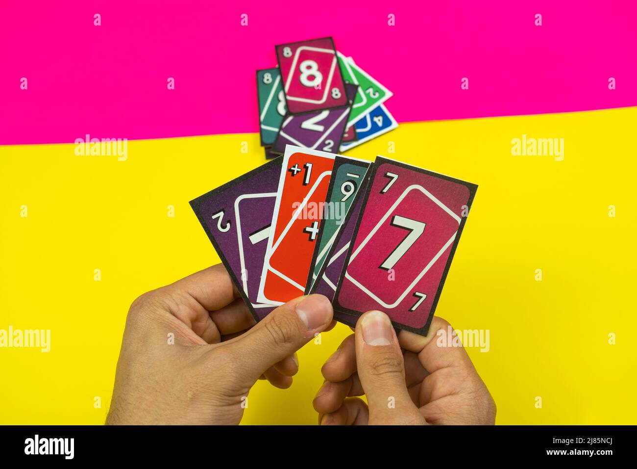 Spielkarten, buntes Kartenspiel, gelber und rosafarbener Hintergrund, Unterhaltung und Spaßkonzept, hängen mit Freundinnen-Idee, Draufsicht Stockfoto