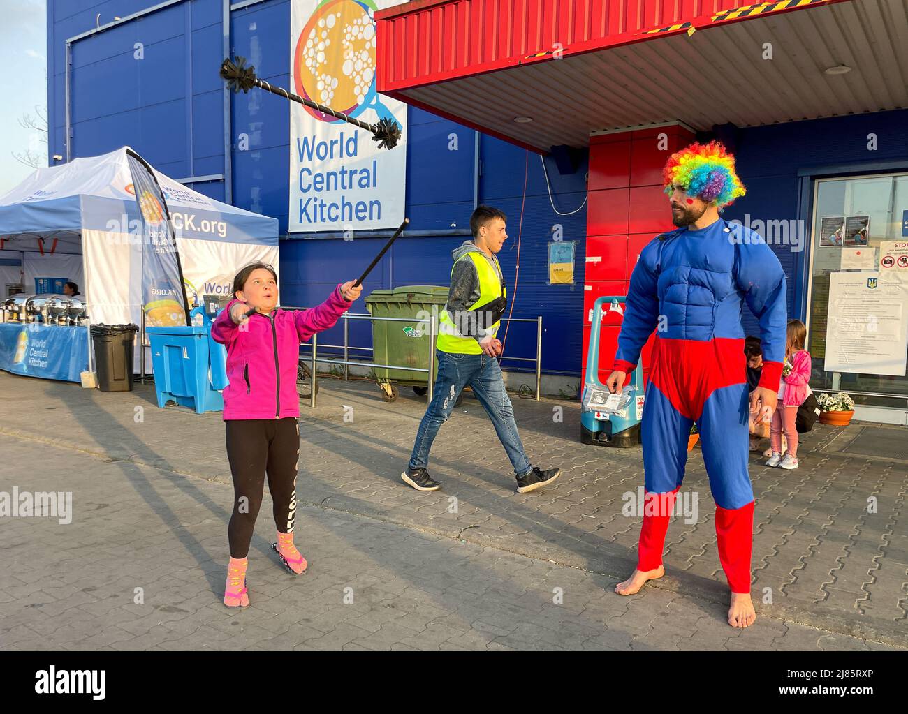 Przemysl, Polen:12. Mai 2022, Georgie aus Berlin, mit Mobile Circus for Peace und Cabuwazi, Wanderzirkus für Kinder, spielt mit den Flüchtlingskindern und tritt für die Erwachsenen im Tesco auf, einem ukrainischen Zentrum für humanitäre Hilfe in Przemysl, Polen, in der Nähe der Grenze zu Medyka, Hunderte von traurigen Menschen, die gerade aus Charkiw, Kiew, Odessa und anderen von russischen Invasoren beschlagnahmten Orten in der einladenden polnischen Grenzstadt angekommen sind, wurden zum Lachen gebracht. Hier spielen Kinder zusammen oder lächelnde Erwachsene sind ein sehr ungewöhnlicher Anblick: Für kurze Zeit half ihnen der Zirkus zu vergessen Stockfoto