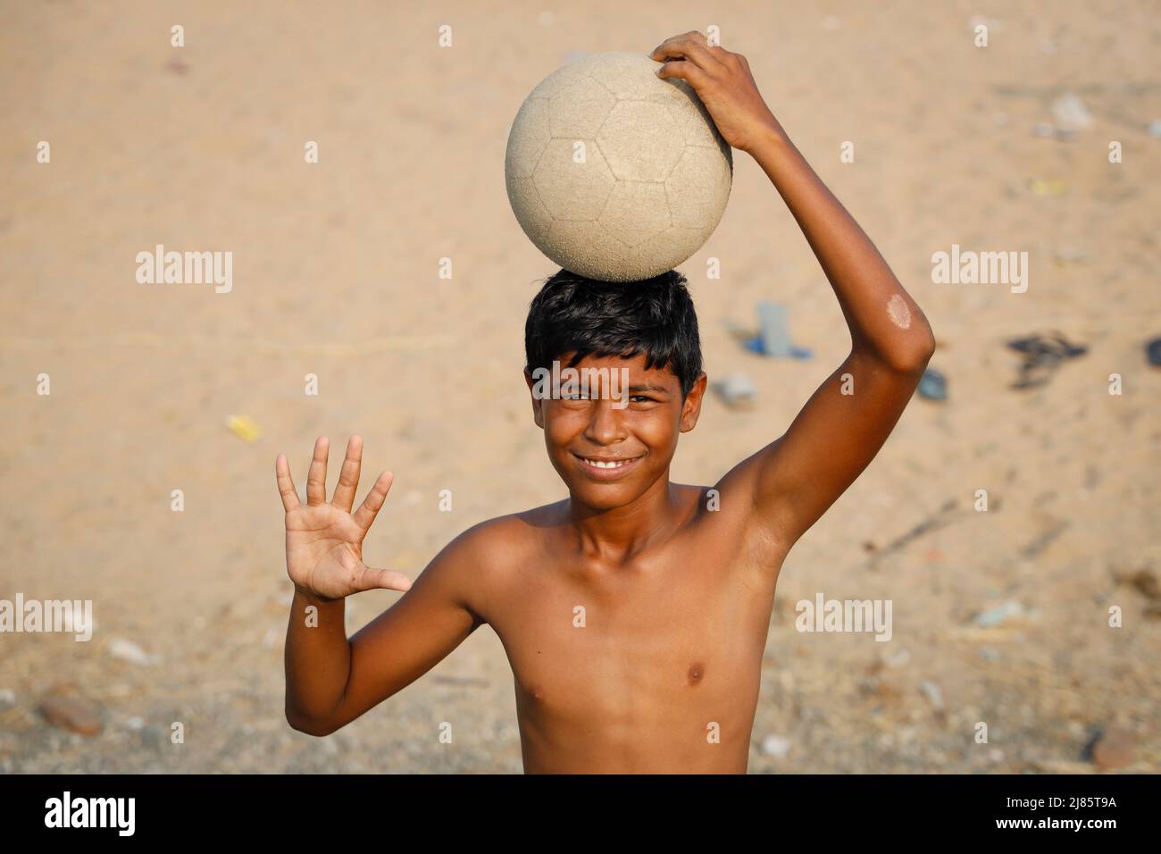 Kleiner Junge mit einem Fußball auf dem Kopf in Tangassery, Thangassery, Kerala, Indien. Stockfoto