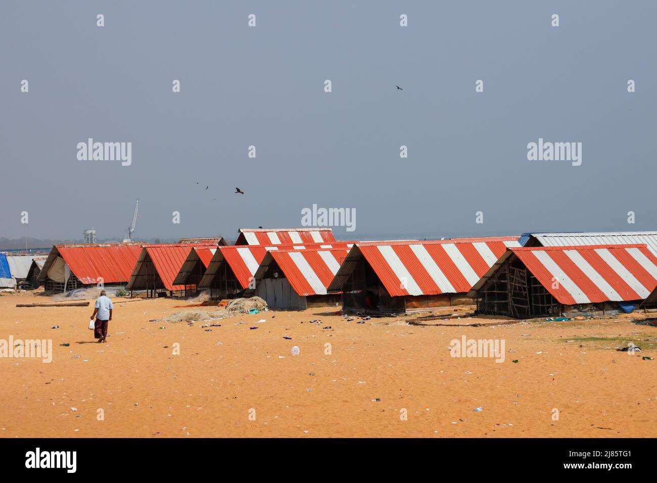 Reihe von Fischerhütten mit rotem und weißem Zinndach, Tangassery, Thangassery, Kerala, Indien Stockfoto