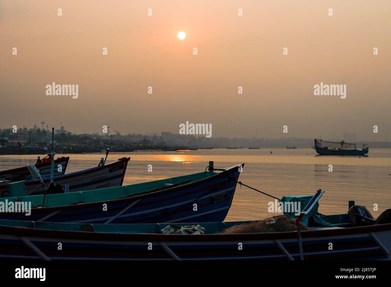 Reihe von Fischerbooten Silhouetten auf dem Strand in Tangassery, Kerala, Indien. Stockfoto