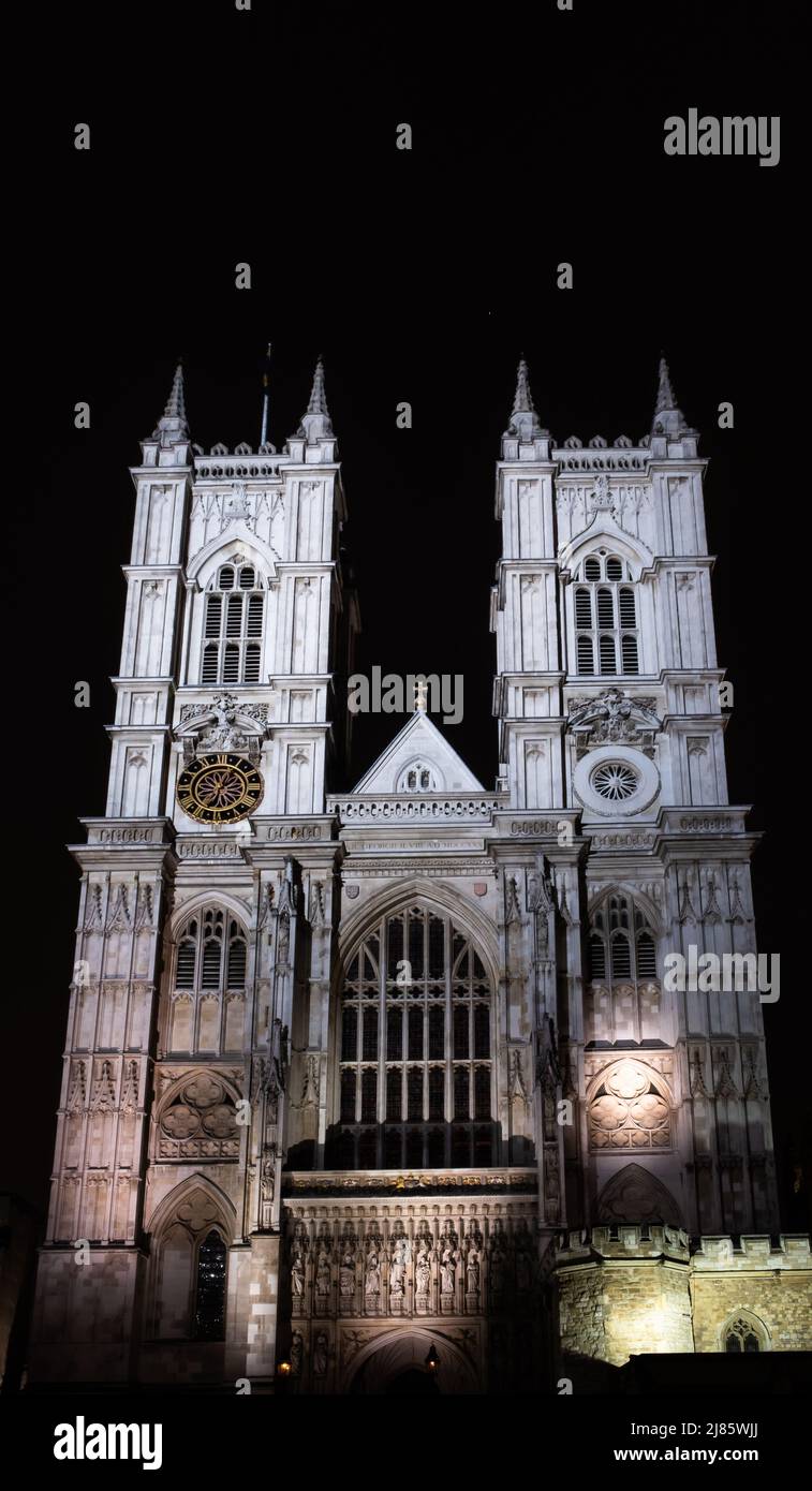 Die Vorderseite der Westminster Abbey, London, beleuchtet bei Nacht. Stockfoto