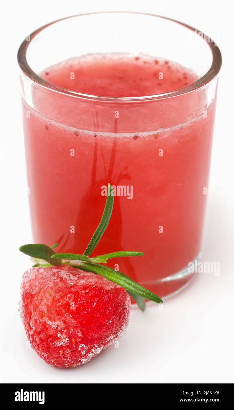 Erdbeersaft in einem Glas mit gefrorenen Früchten Stockfoto