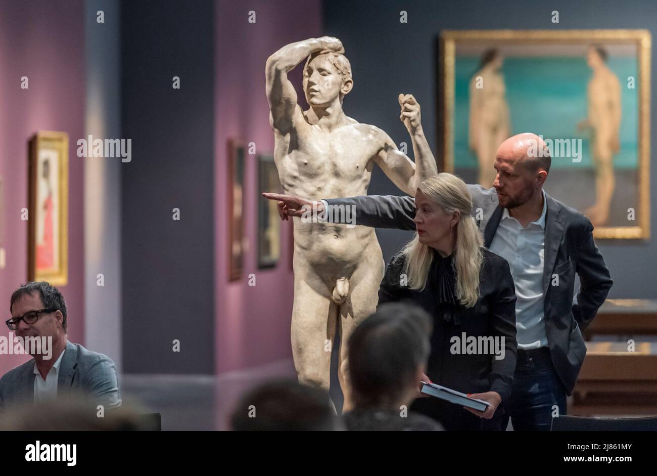 Dresden, Deutschland. 13.. Mai 2022. Besucher und Medien stehen neben August Rodins 'The Brazen Age, 1877' während der Vorschau der Ausstellung 'Weltflucht und Moderne. Oskar Zwintscher in Kunst um 1900' im Albertinum in Dresden. Die Staatlichen Kunstsammlungen Dresden zeigen die Ausstellung vom 14. Mai 2022 bis zum 15. Januar 2023 mit insgesamt 88 Gemälden, 10 Skulpturen, 25 Zeichnungen und 2 Aquarellen von Zwintscher und anderen Künstlern seiner Zeit. Quelle: Matthias Rietschel/dpa/ZB/dpa/Alamy Live News Stockfoto