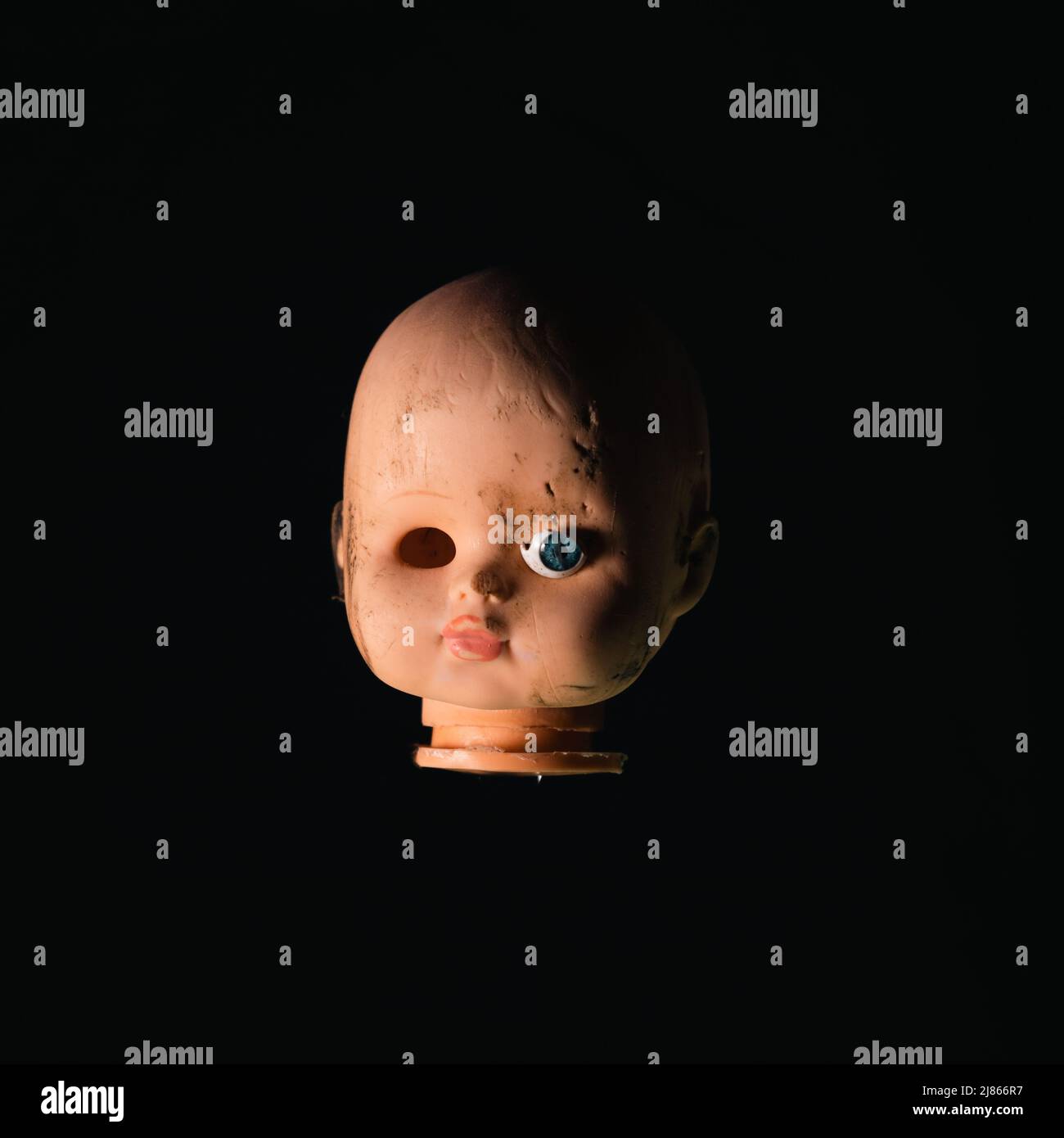 Beschädigter Dirty Doll Kopf auf schwarzem Hintergrund Stockfoto
