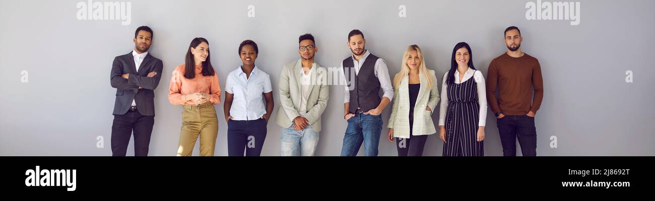 Banner mit einer Gruppe junger, vielfältiger Modelle in eleganter, lässiger Bürokleidung, die im Studio posiert Stockfoto