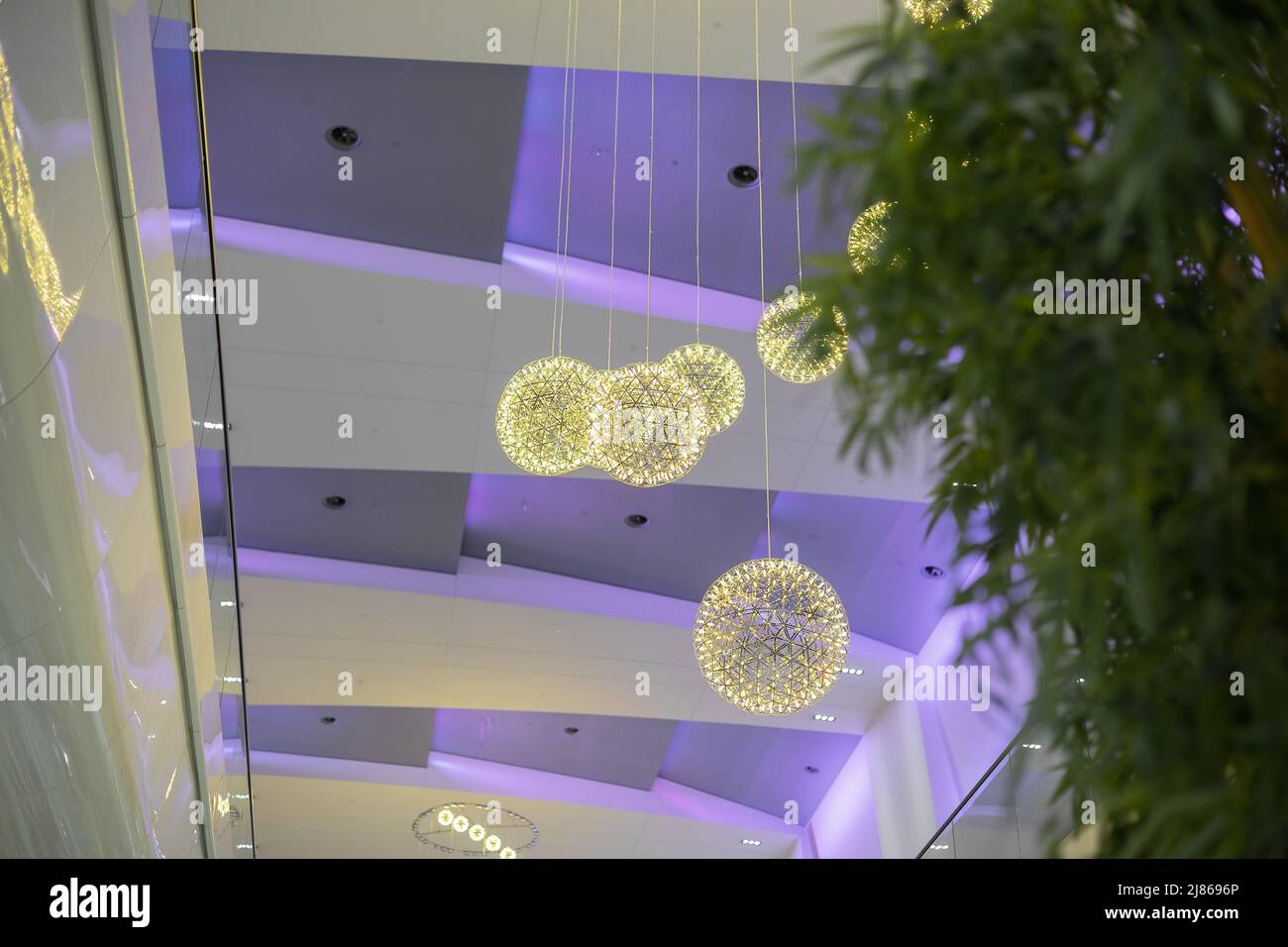 Im Einkaufszentrum hängen gemusterte, leuchtende Kugeln an der Decke Stockfoto