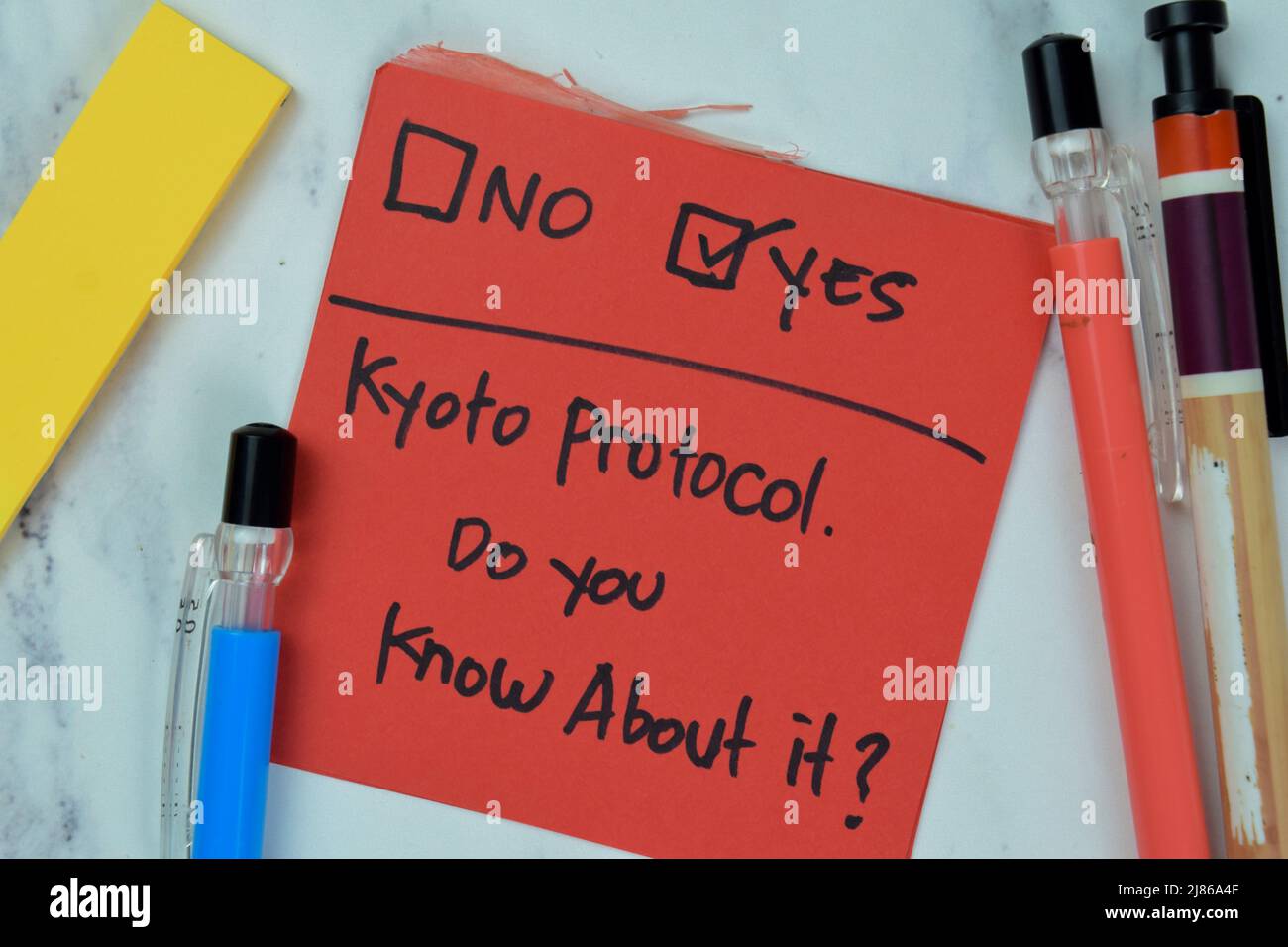Das Konzept des Kyoto-Protokolls, wissen Sie darüber Bescheid? Nein oder Ja Schreiben Sie auf Haftnotizen isoliert auf Holztisch. Stockfoto