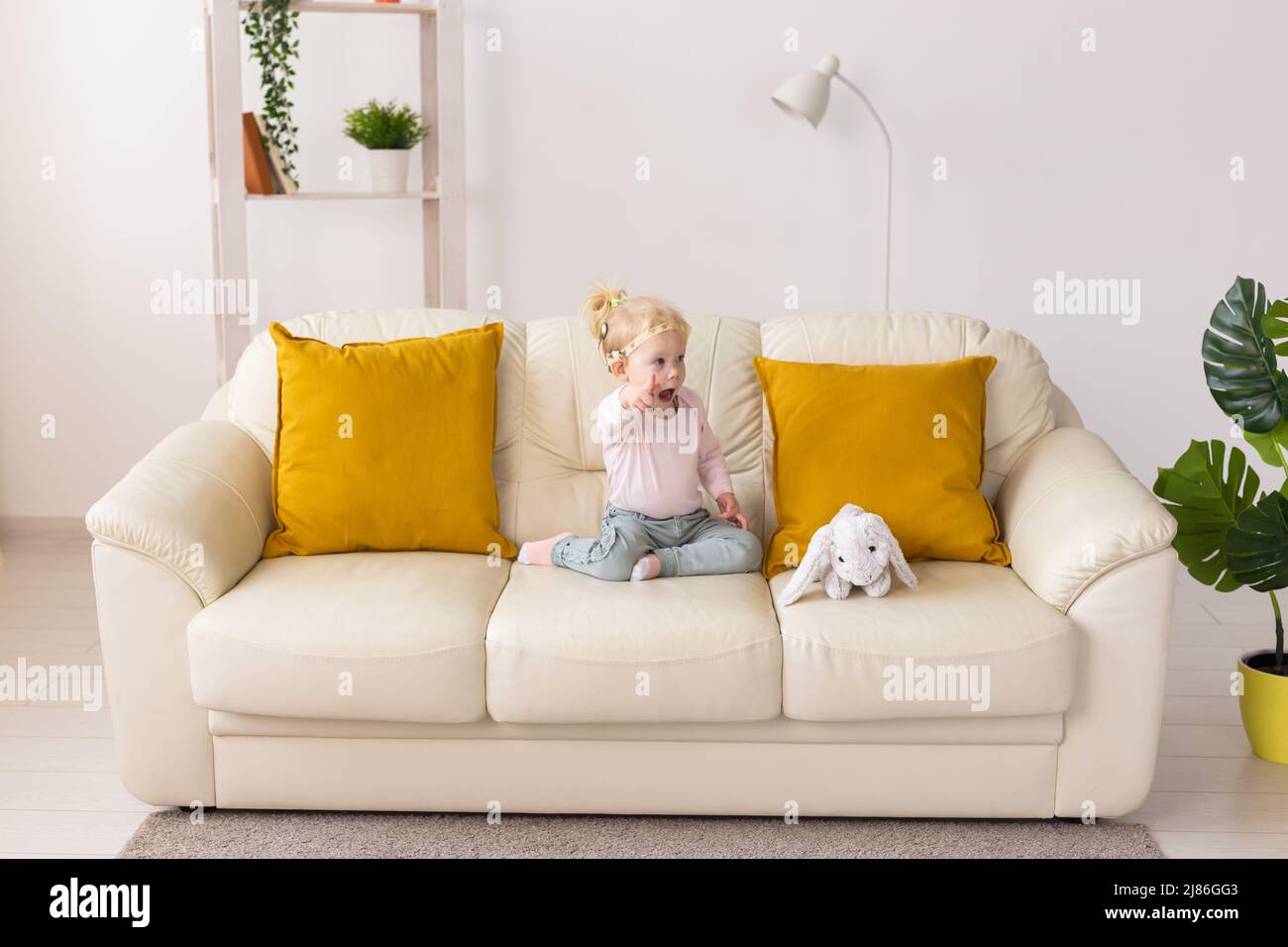 Kind mit Cochlea-Implantaten sitzt zu Hause auf dem Sofa. Taubheit und Medizintechnikkonzept. Stockfoto
