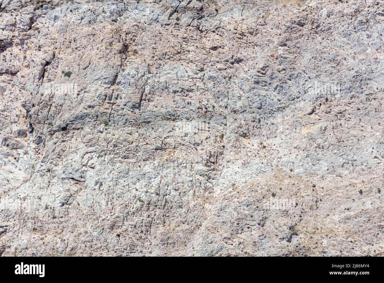 Grauer Fels, geformt vom Meer, Salz und Wind Hintergrundstruktur. Steinbildung, raues mineralisches Material. Abstrakte natürliche Felsoberfläche. Griechische Insel G Stockfoto