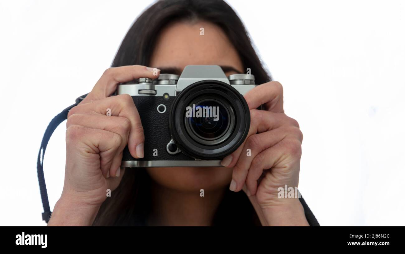 Junge Frau hält Fotokamera ist die Aufnahme Ihres Bildes isoliert auf weißem Hintergrund. Mädchen Fotograf Fokus auf Sie, Nahaufnahme Stockfoto