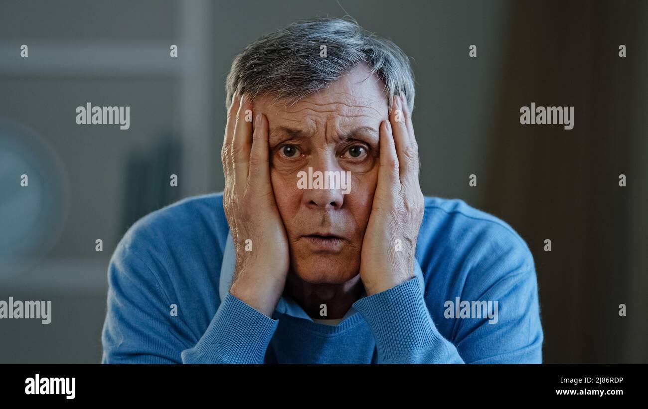 Depressiv frustriert alten älteren kaukasischen Mann schockiert traurig ältere ältere 60s männliche Gefühl besorgt Blick auf Kamera halten Kopf gestresst Geschäftsmann Stockfoto