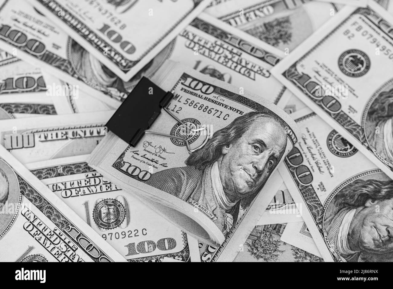 100-Dollar-Banknoten mit Binderclip auf Dollar-Hintergrund für Designzwecke Stockfoto