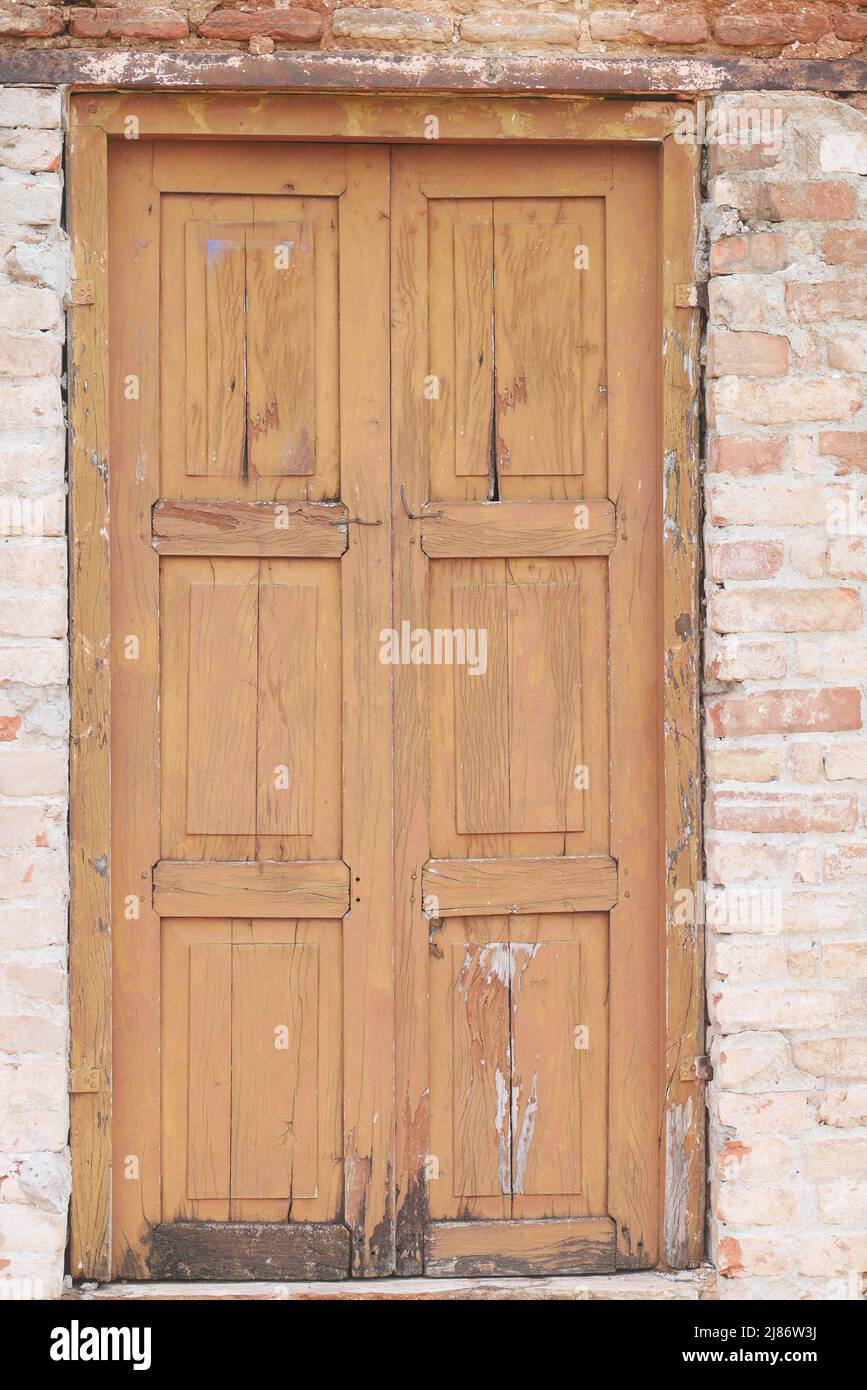 Alte Holztür in Betonwand, Stockfoto