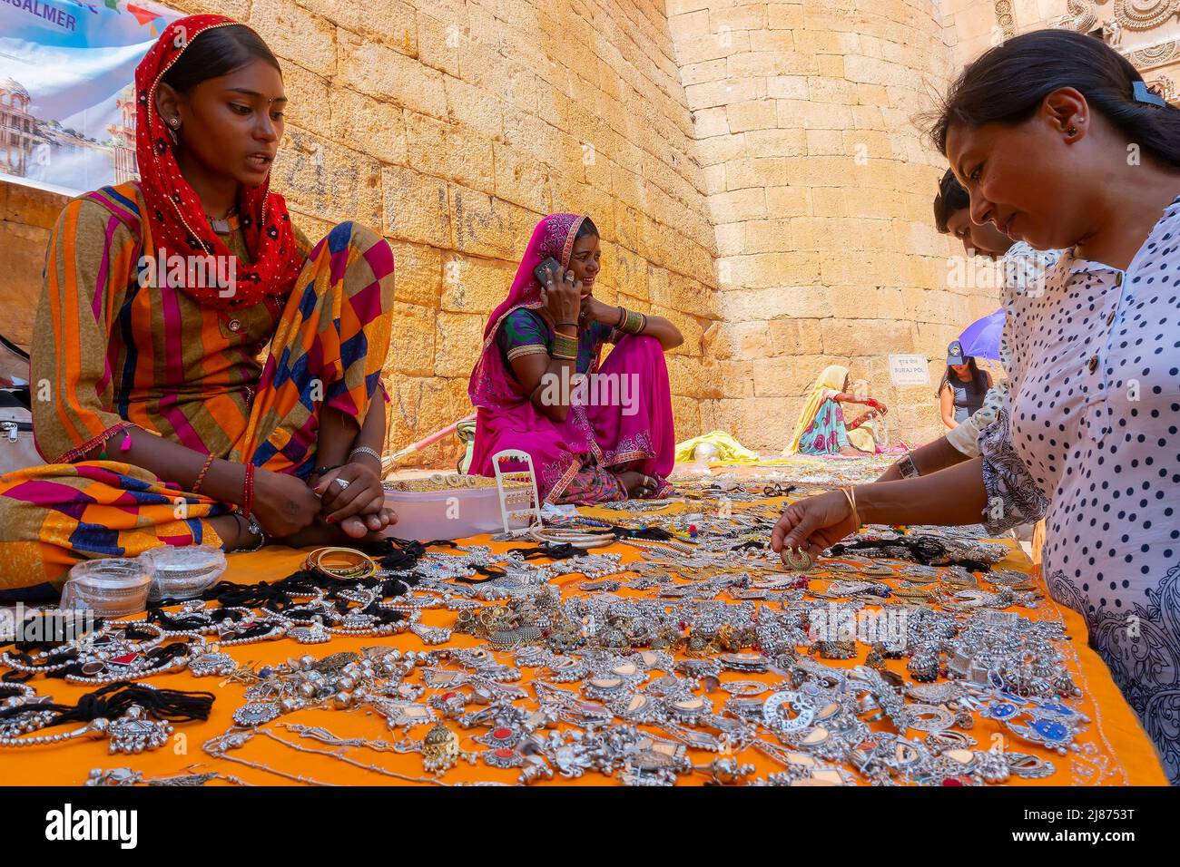 Jaisalmer, Rajasthan, Indien - 13. Oktober 2019 : Rajasthani Frauen verkaufen und verhandeln Preis von Schmuck mit weiblichen Touristen in Marktplatz ins Stockfoto