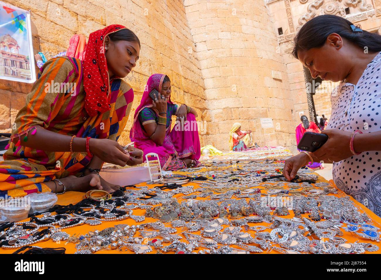 Jaisalmer, Rajasthan, Indien - 13. Oktober 2019 : Rajasthani Frauen verkaufen und verhandeln Preis von Schmuck mit weiblichen Touristen in Marktplatz ins Stockfoto
