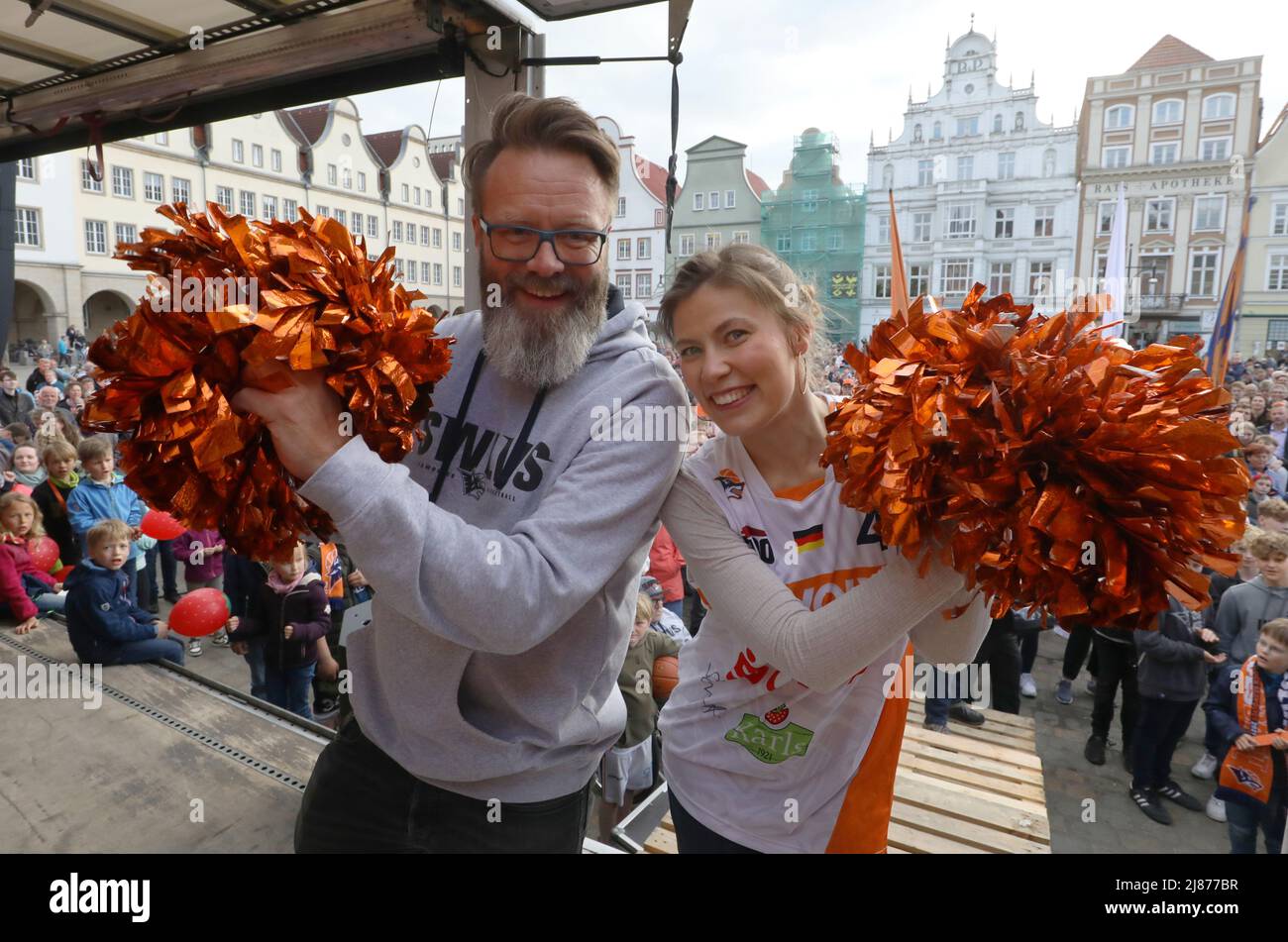 Rostock, Deutschland. 13.. Mai 2022. Rostocks Bürgermeister Claus Ruhe Madsen (nicht-Partei) steht mit einem Cheerleader auf dem Neuen Markt und feiert die Beförderung der Herren-Basketballmannschaft der Rostock Seawolves zur Basketball-Bundesliga 1.. In der letzten Sekunde hatte das Team 77-76 in Jena gewonnen und steigt damit erstmals in der Bundesliga. Quelle: Danny Gohlke/dpa/Alamy Live News Stockfoto