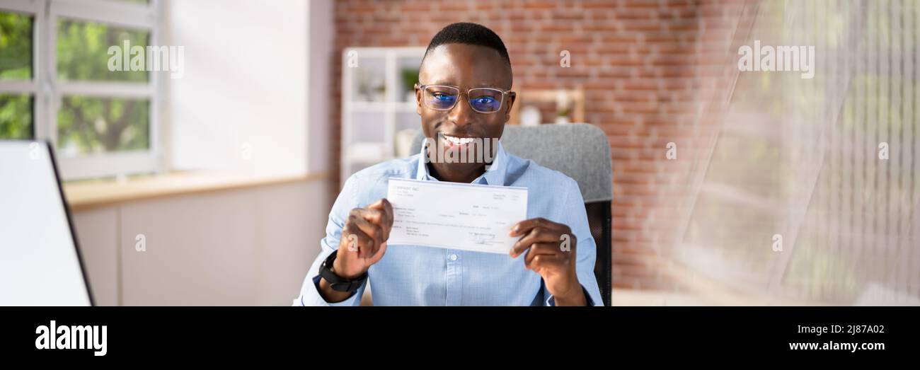 Nahaufnahme EINES lächelnden Geschäftsmannes, der den Firmencheck zeigt Stockfoto