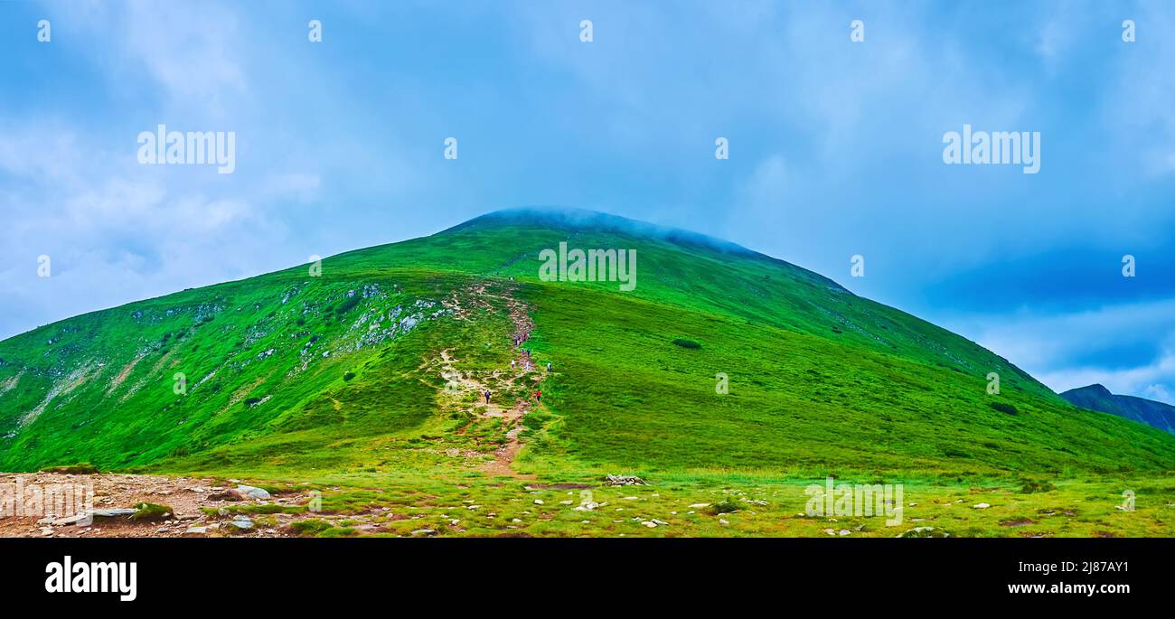 Panorama der alpinen Tundra-Zone des Berges Hoverla mit niedrigen Wolken und Wanderer auf schmalen Wegen, Karpaten, Ukraine Stockfoto