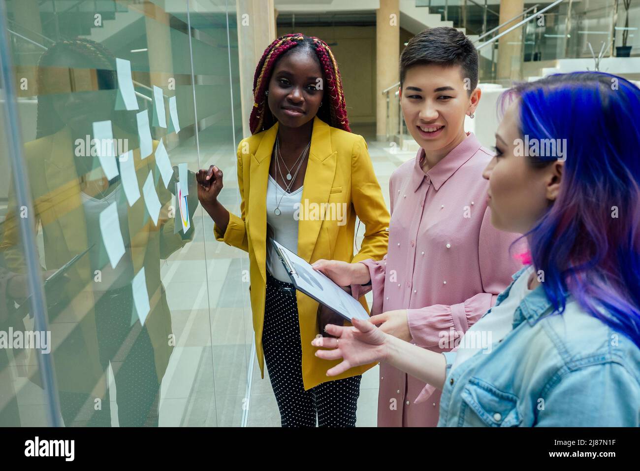 Mixed-Race-Journalist Modedesigner arbeiten in einem hellen Büro zusammen Stockfoto