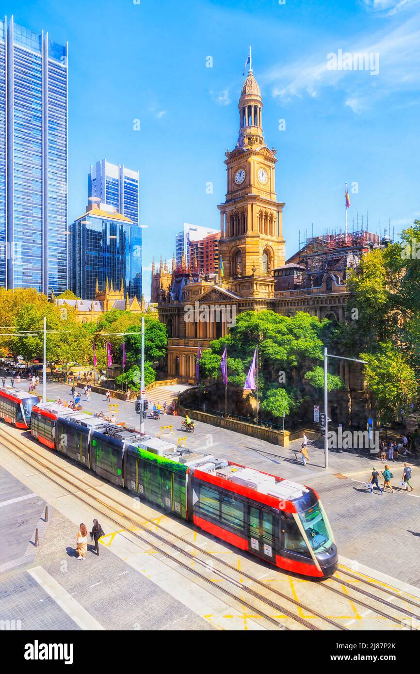 Rathaus im zentralen Geschäftsviertel von Sydney in der George Street mit elektrischer Straßenbahn auf Schienen - malerisches Stadtbild. Stockfoto