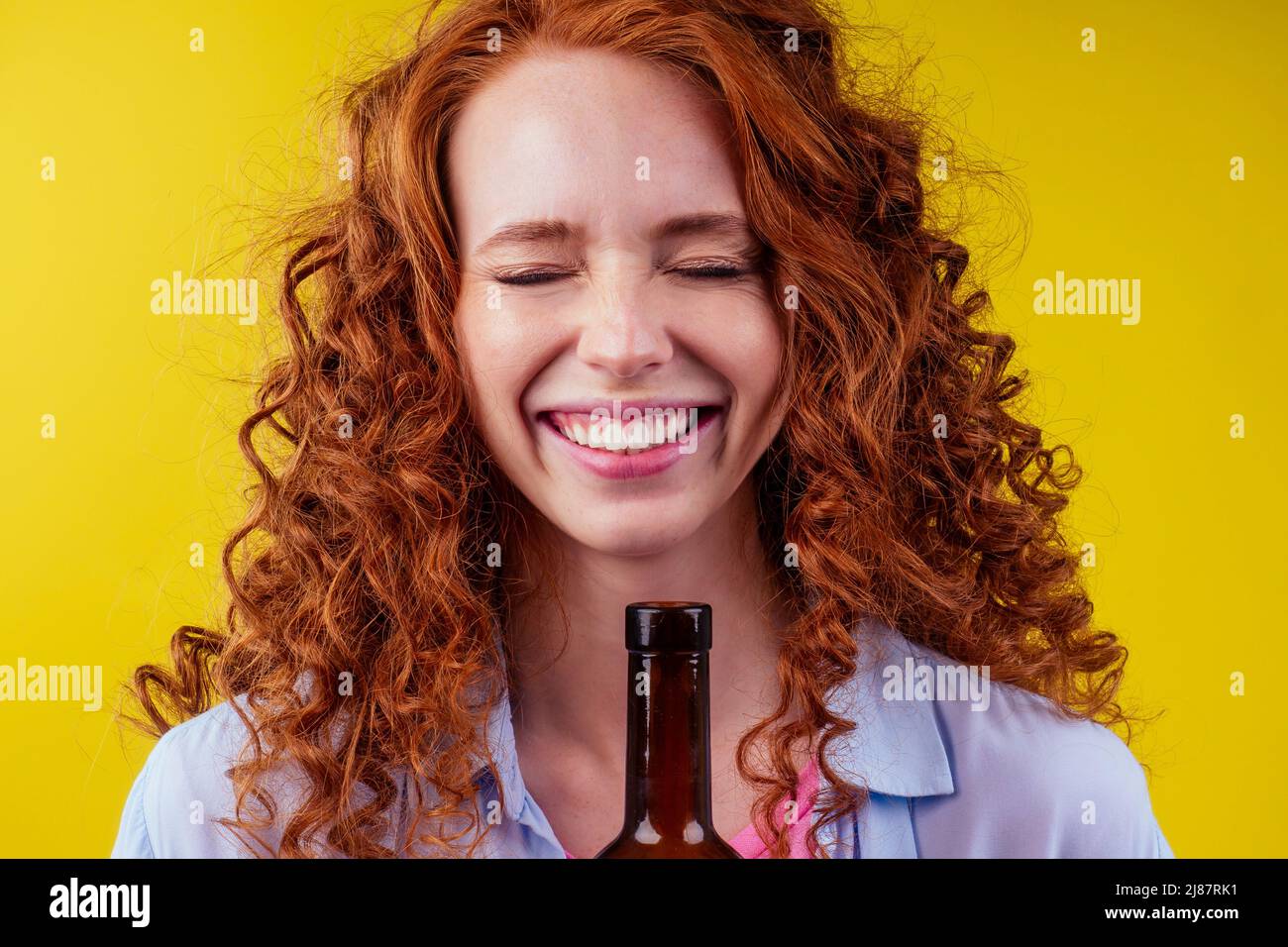 Rothaarige Ingwer Frau hält alkoholfreien Alkohol Weinflasche und Gefühl gute Emotionen Stockfoto