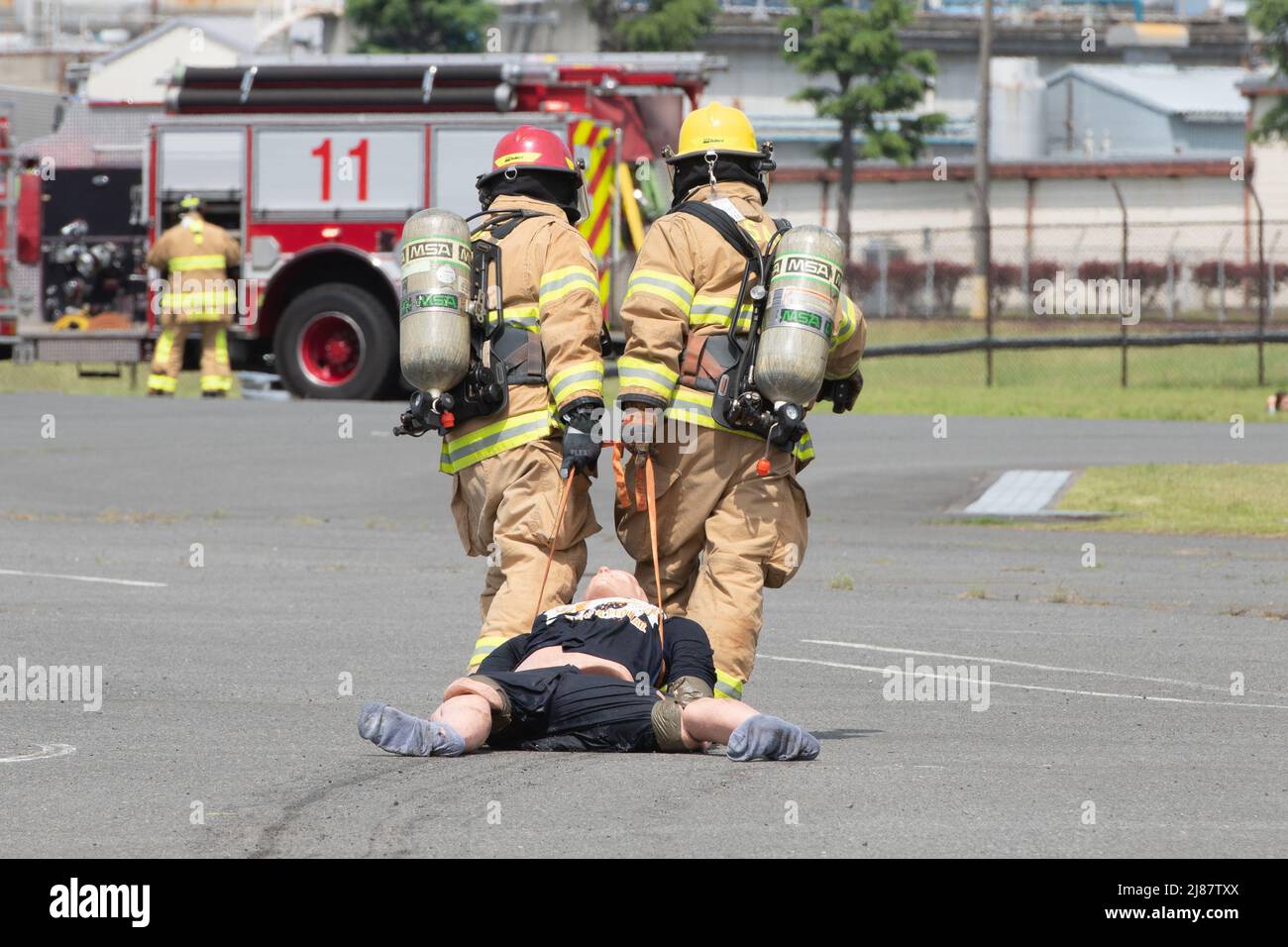 Feuerwehrleute mit der 374. Civil Engineer Squadron Fire Department bringen eine simulierte Verletzte während einer schweren Übung zur Reaktion auf einen Unfall auf dem Yokota Air Base, Japan, 11. Mai 2022 in Sicherheit. Die MARE testete die Reaktion der Basis auf einen simulierten F-16 Kampf gegen Falcon Absturz und die Fähigkeit, mit Missionspartnern zusammenzuarbeiten. Dank der Unterstützung der Naval Air Facility Atsugi, Commander Fleet Activities Yokosuka, des Misawa Air Base und der Tokyo Fire Department, der Fussa Fire Station, war dies die größte MARE in der Geschichte von Yokota. (USA Luftwaffe Foto von Machiko Arita) Stockfoto