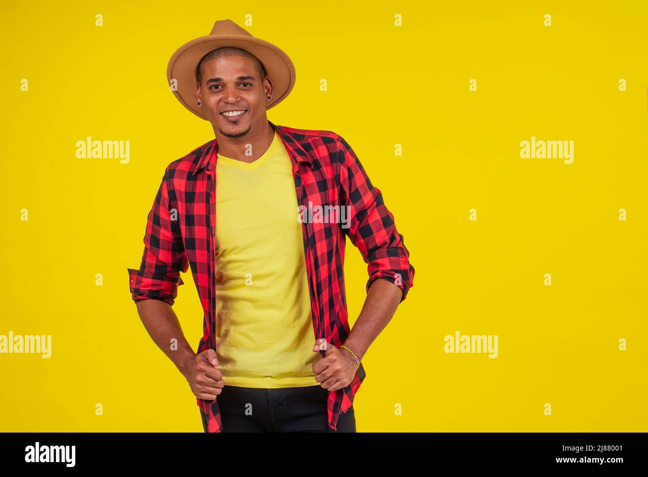 arabischer brasilianischer Mann posiert im Studio auf gelbem Hintergrund Stockfoto