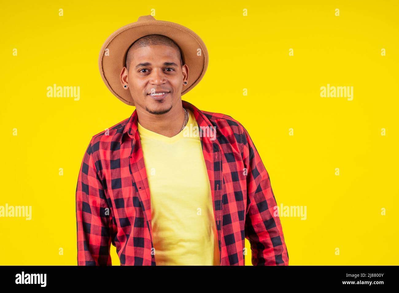 arabischer brasilianischer Mann posiert im Studio auf gelbem Hintergrund Stockfoto