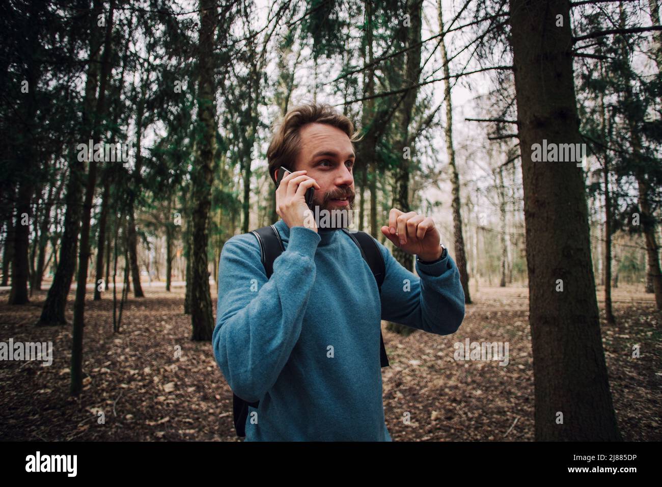 Junge erwachsene Mann am Telefon zu sprechen stehend über weiße Mauer mit Hand betonte am Kopf, mit Scham und Überraschung Gesicht schockiert, wütend und frustr Stockfoto