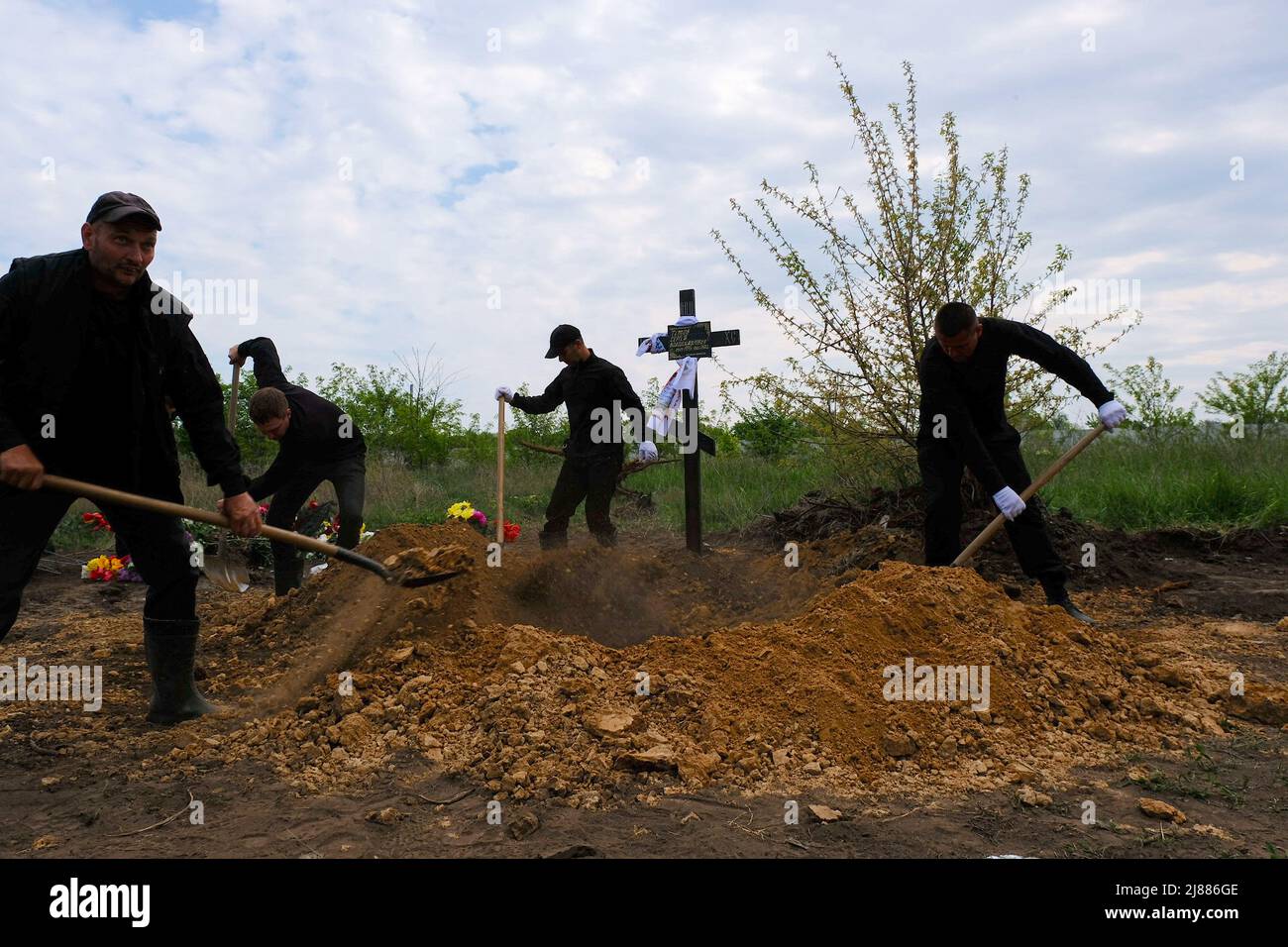 Balabyne, Ukraine. 13.. Mai 2022. Die Arbeiter der Trauerhalle bedecken den Sarg mit Erde. Russland marschierte am 24. Februar 2022 in die Ukraine ein und löste damit den größten militärischen Angriff in Europa seit dem Zweiten Weltkrieg aus Kredit: SOPA Images Limited/Alamy Live Nachrichten Stockfoto