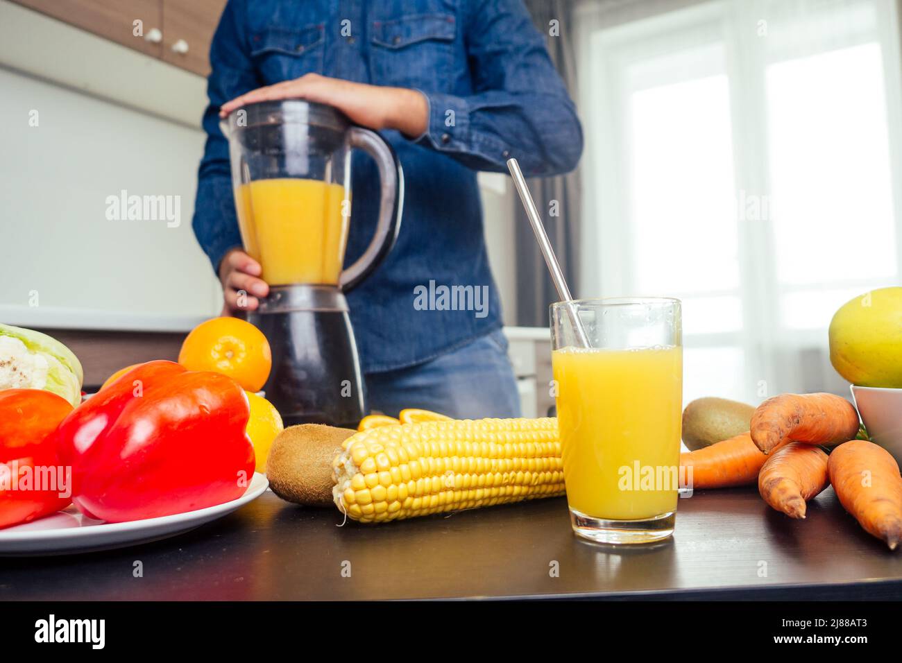 Ein junger inder in der Küche bereitet einen frischen Orangensaft zu Stockfoto