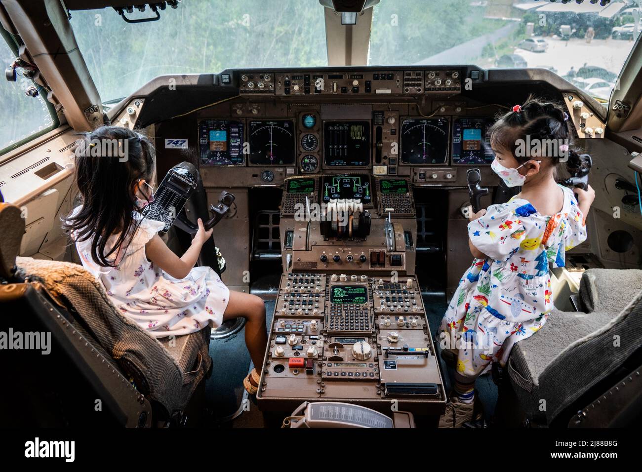 Samut Prakan, Thailand. 14 Mai 2022. Kinder spielen Piloten im Cockpit eines pensionierten Boeing 747-Flugzeugs, das in ein Café umgewandelt wurde. Matt Hunt/Neato. Kredit: Matt Hunt / Neato/Alamy Live Nachrichten Stockfoto