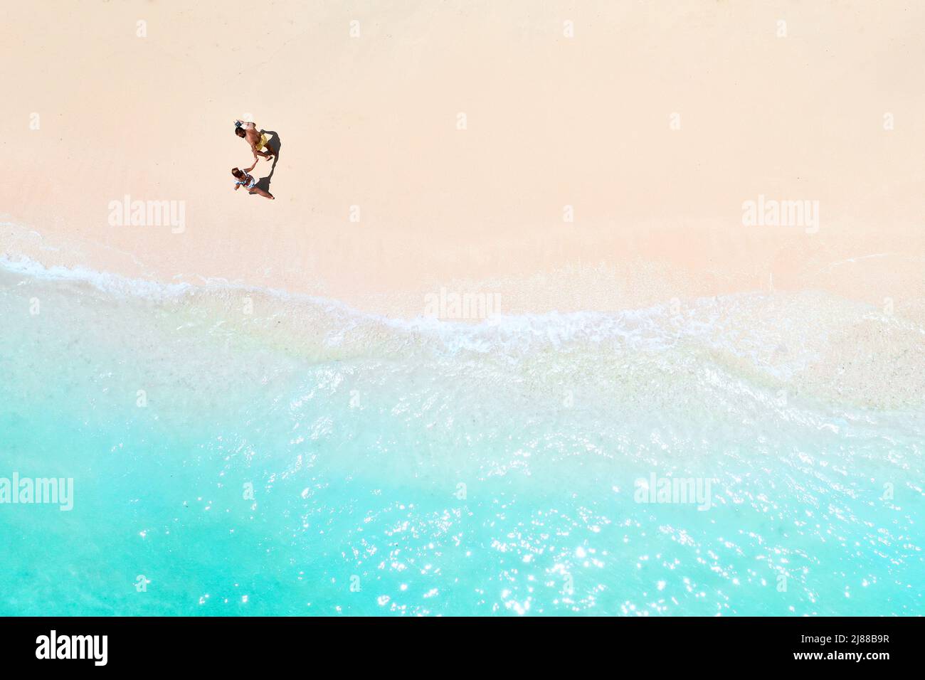 Ein paar Spaziergänge am Strand von Mauritius im Indischen Ozean. Draufsicht auf den Strand mit türkisfarbenem Wasser auf der tropischen Insel Mauritius.Luftaufnahme Stockfoto